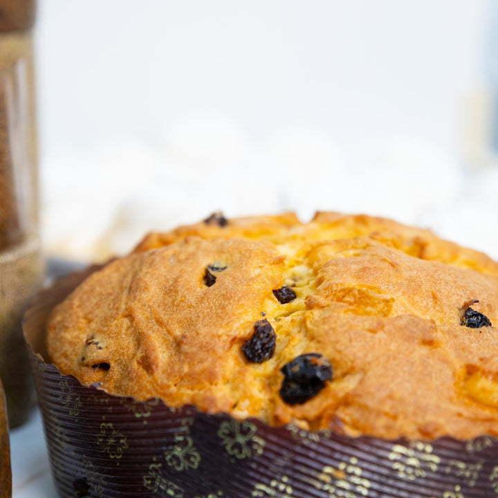 Panettone con uvetta e canditi in primo piano, sfondo chiaro