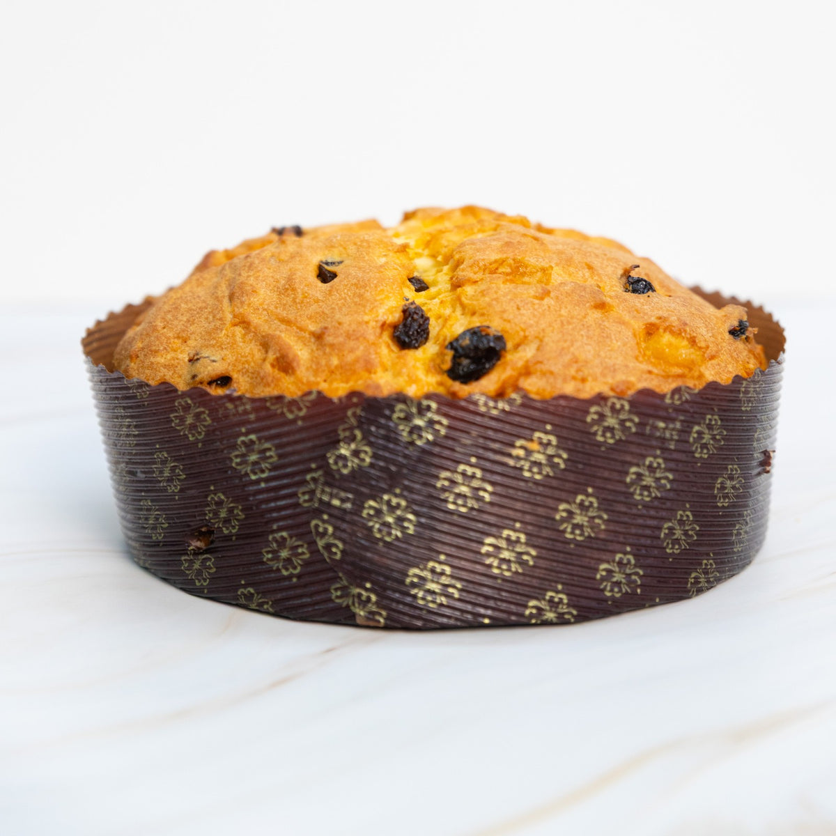 Panettone con uvetta e canditi nel pirottino decorato, vista frontale a distanza