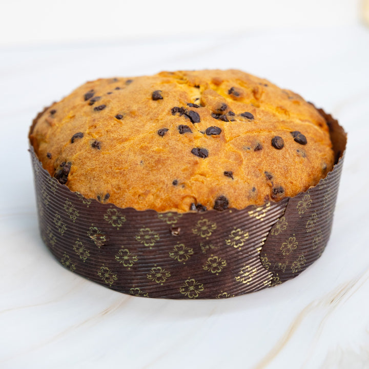 Panettone con gocce di cioccolato nel pirottino marrone decorato, vista frontale